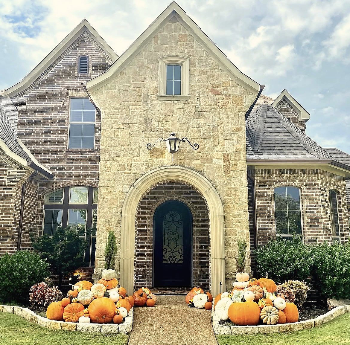 Grand Harvest pumpkin porch display on stone estate home